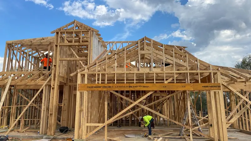 Two storey wood framing going up on a residential build under clear skies