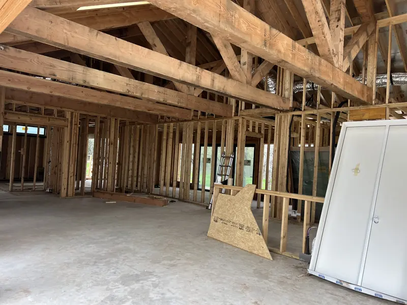 Interior framing with exposed roof trusses before drywall
