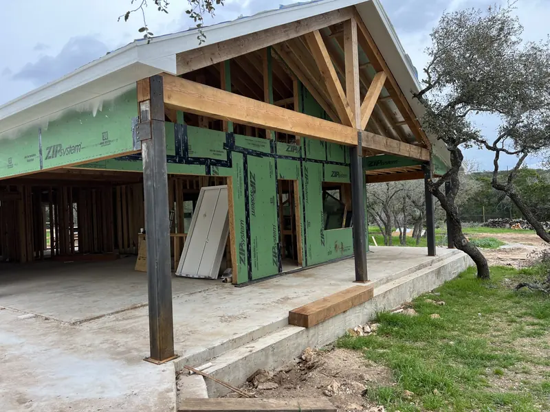 Timber frame covered porch under construction on a Hill Country home