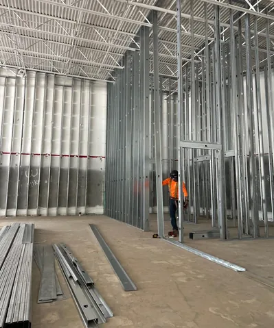 Crew setting steel stud partitions against the wall of the cleared unit