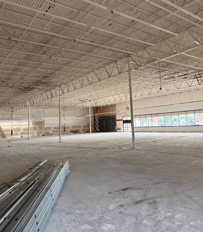 Bare concrete slab swept clean after strip out, with steel stud track stacked ready for framing