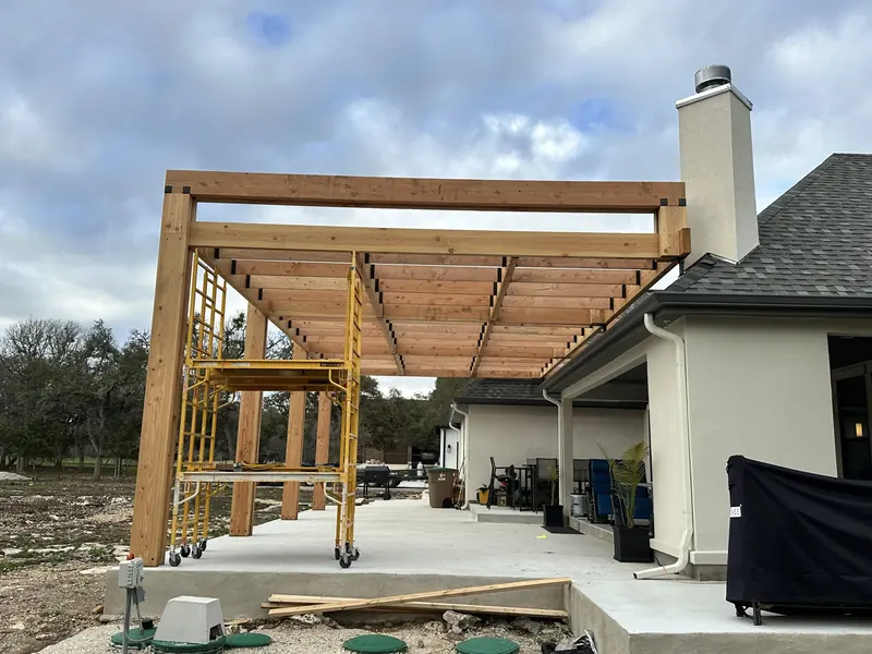 Cedar pergola framing installed over a rear patio