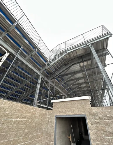 Commercial chain link safety fencing fitted to the steel underside of a stadium grandstand