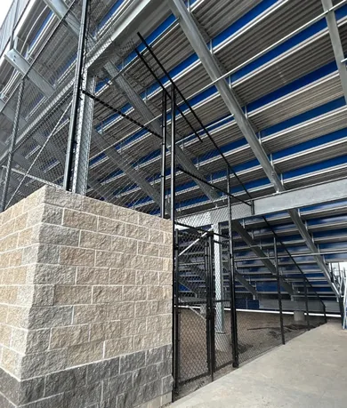 Black chain link gates and fencing enclosing the space under a grandstand